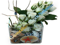 Cam vazo içerisinde deniz kabukları ve nazar boncukla süslenmis 20 adet beyaz Gül den oluşan zarif çiçek.
